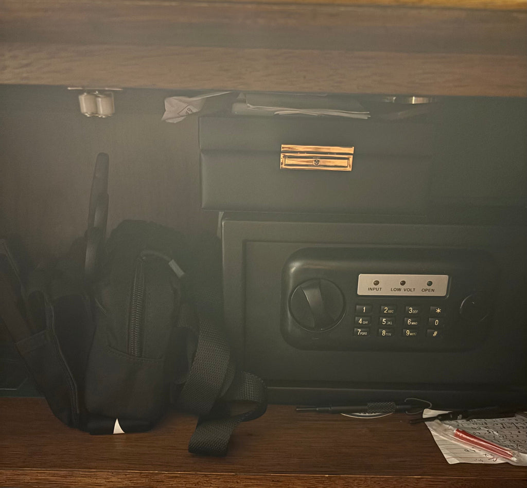 Minuteman IFAK sling kit staged beside a bedside safe — compact and ready for home emergency response