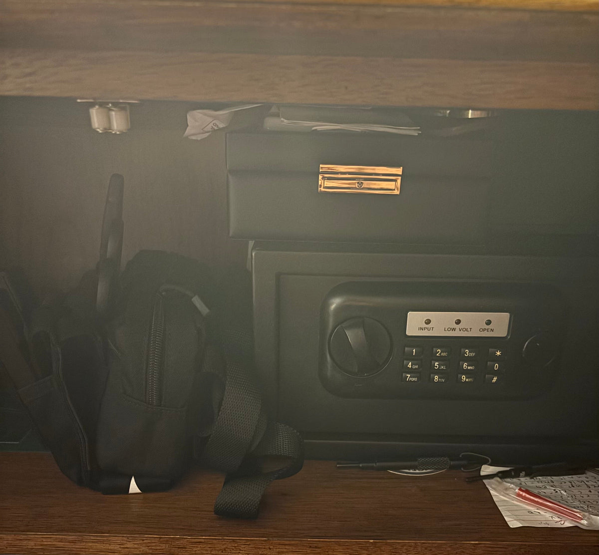 Minuteman IFAK sling kit staged beside a bedside safe — compact and ready for home emergency response