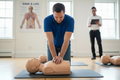 Rescuer kneeling to the side of manikin performing CPR